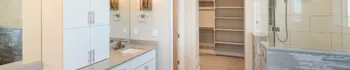 Bathroom remodel with white vanity cabinets, glass shower, built-in shelving, and bright modern finishes by King Contractor LA