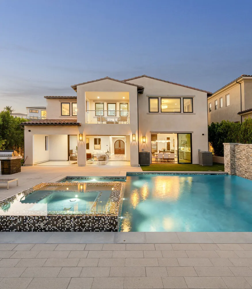 Backyard remodeling project in Los Angeles featuring a luxury pool, spa, outdoor patio, modern lighting, two story home exterior, and resort style outdoor living space