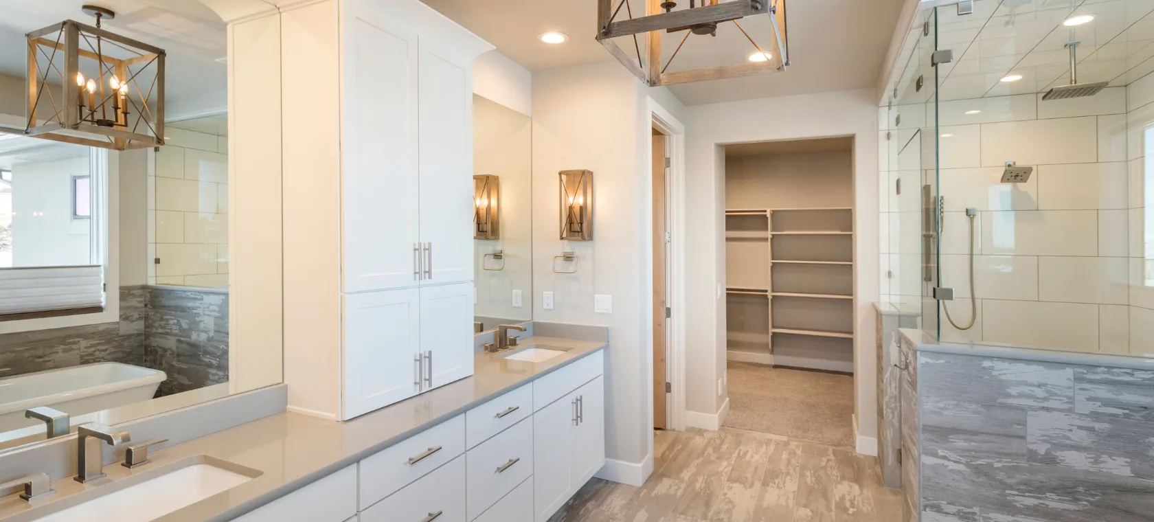 After bathroom remodeling project in Los Angeles featuring a modern white vanity, glass shower enclosure, walk in closet access, upgraded lighting, tile flooring, and spa inspired bathroom design