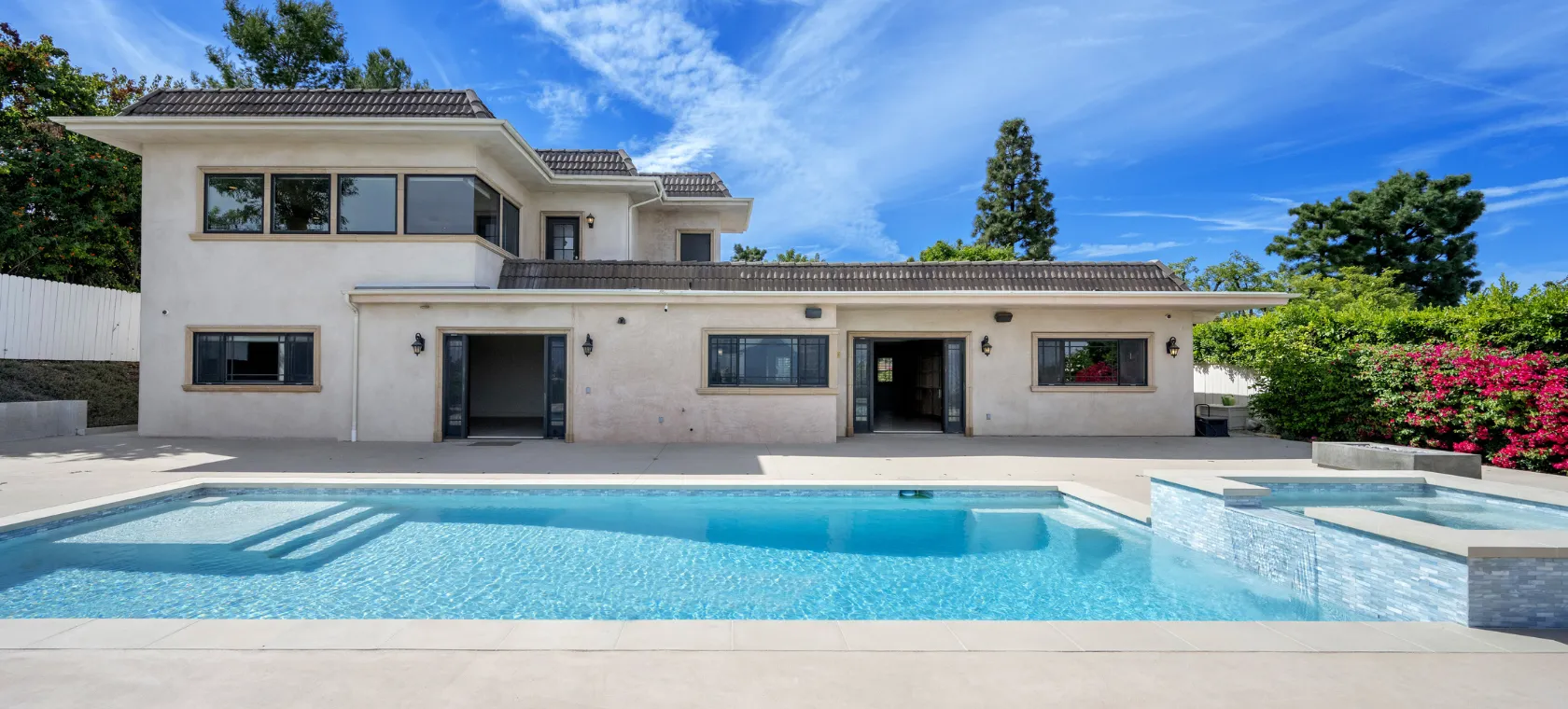 After room additions project in Los Angeles featuring a modern poolside home expansion with large openings, updated exterior, patio space, spa, pool, and improved indoor outdoor connection