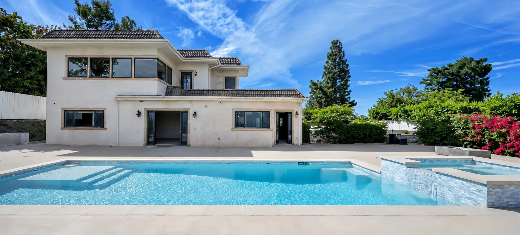 Before room additions project in Los Angeles showing the rear of a home with pool, patio area, existing openings, and unused exterior space ready for a home expansion