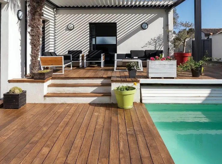 Backyard remodeling in Los Angeles featuring a wood deck, modern patio seating area, pergola shade, planters, and a small pool for outdoor living