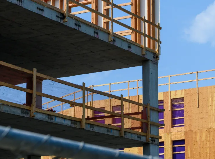 Commercial construction in Los Angeles with a multi story building structure, concrete framing, wood safety rails, and active structural development