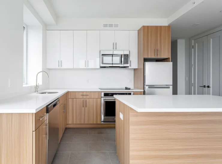Kitchen remodeling in Los Angeles with modern wood base cabinets, white upper cabinets, clean countertops, center island, and updated appliances